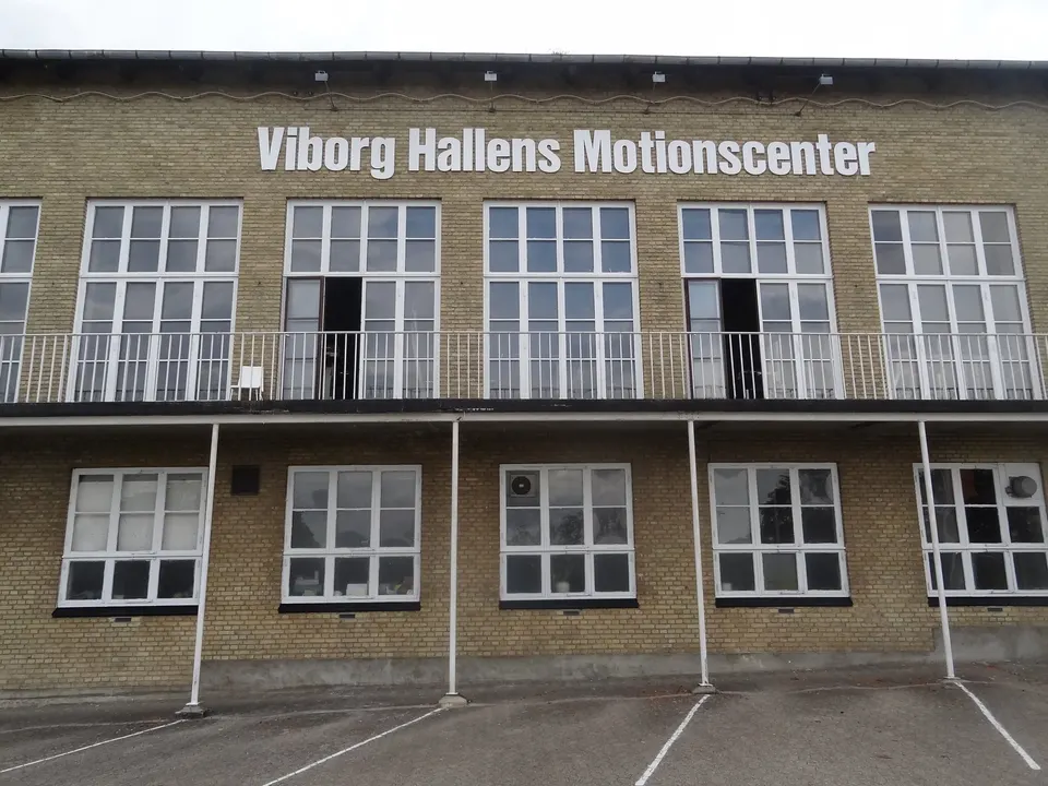 Facaden med skiltet Viborg Hallens Motionscenter og parkeringsbåse foran
