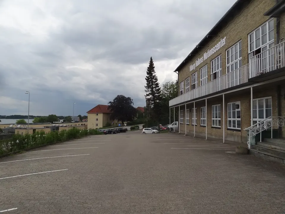 Parkeringspladsen langs Viborg Hallens lange gule facade